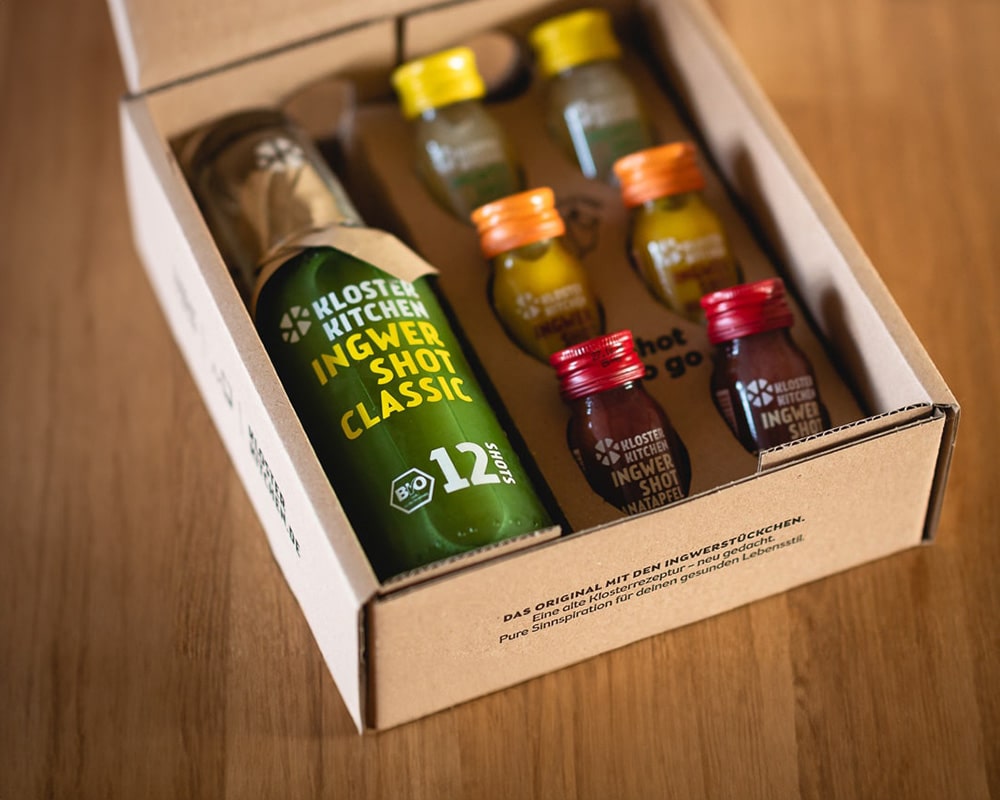 Kundengeschenke bildlich dargestellt: Ein schicke Box geöffnet, in der Box sieht man Ingwer Shots in verschiedenen Größen